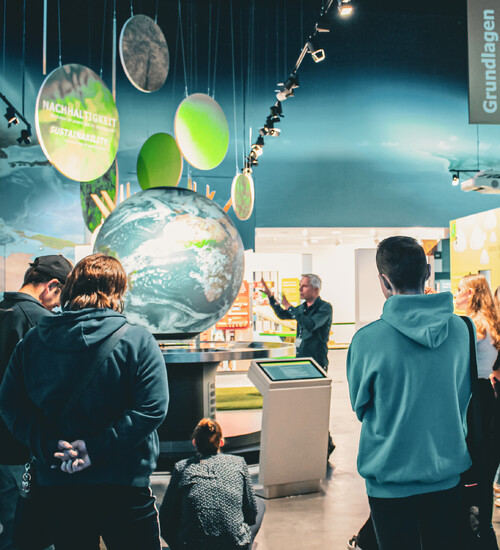 Gruppe bei F&uuml;hrung am interaktiven Globus in der KLIMA ARENA.